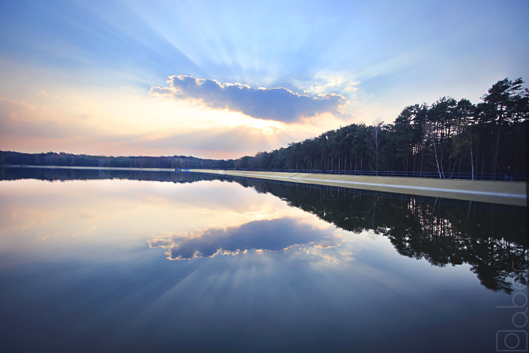 Słońce za chmurą nad zalewem Kobyla Góra